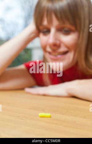 Woman with tablet. Deciding whether to take tablet. Stock Photo