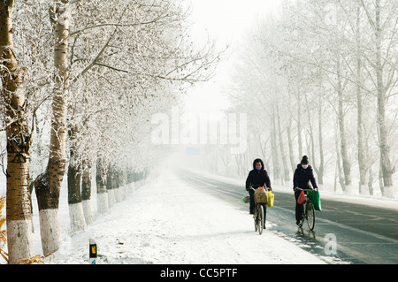 People riding bike on a country road, Jilin, Jilin , China Stock Photo