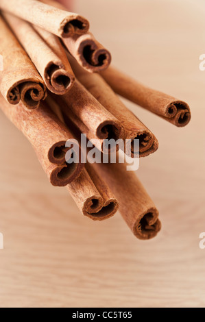 Bunch of Cinnamon Sticks against a light wooden surface Stock Photo