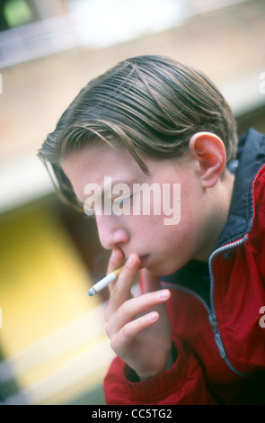 12 year old boys smoking cigarettes in park standing by tree UK Stock ...