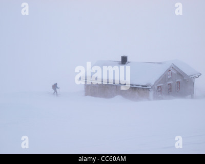 A ski-tourer reaches the safety of a mountain hut in a blizzard, Norway Stock Photo