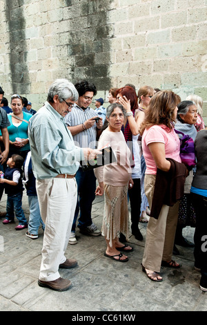 diverse group of Mexican people in line to view folk art sculpture carved from radishes for Noche de Rabanos festival in Oaxaca Stock Photo