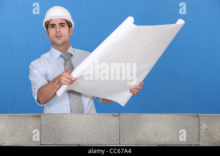Engineer unrolling a technical drawing Stock Photo