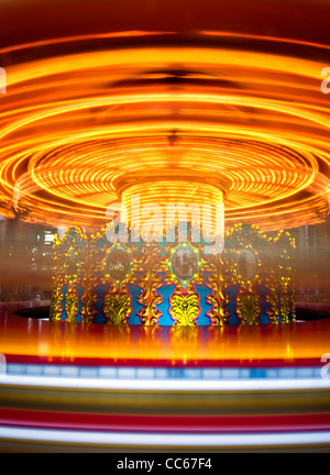 The light trails of a fairground carousel ride captured with a long exposure Stock Photo