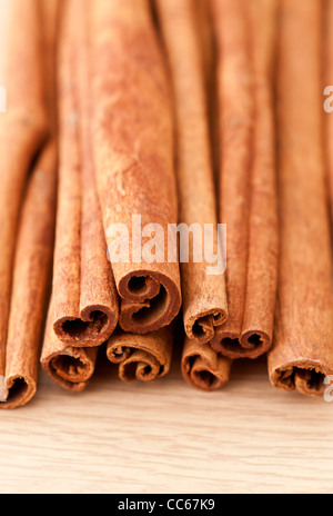 Cinnamon sticks on a wooden table top surface Stock Photo