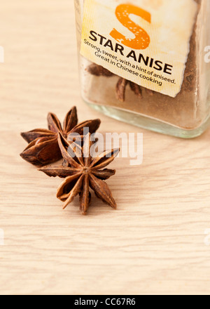 Star Anise on a wooden surface with the spice jar behind Stock Photo