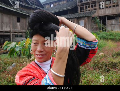 Red Yao woman coiling her long hair, Huangluo Yao Village, Longsheng, Guilin, Guangxi , China Stock Photo