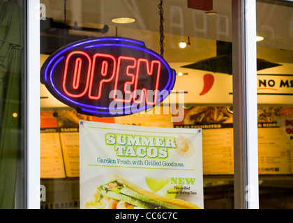 An open neon sign displayed in window - USA Stock Photo