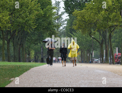 People walking in heavy rain with umbrella and raincoats - USA Stock Photo