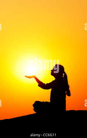 Indian girl holding the sun. Silhouette. India Stock Photo