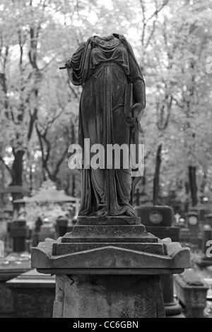 Beheaded sculpture on an old tombstone. BW photograph. Shallow depth of field. Stock Photo