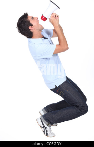 Young man shouting into a megaphone Stock Photo