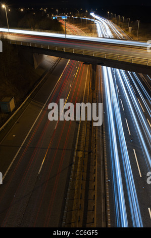 Free flowing motorway traffic at night  vehicles have left trails at the m25 m26 a21 dual carriageway junction flyover bridge Stock Photo