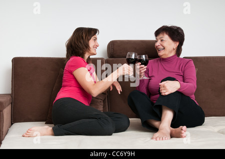 Happy time - mother with daughter drinking wine at home Stock Photo