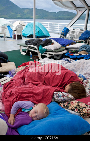 Family sleeping on the deck of the ferry from Bellingham (Washington) to Skagway (Alaska). Inside Passage. USA Stock Photo