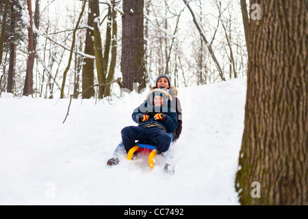 Mother and son riding a sledge in a holiday winter day Stock Photo