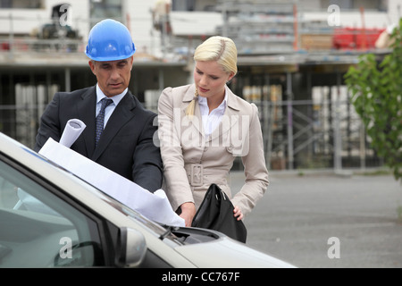 A team of engineers looking at a technical drawing Stock Photo