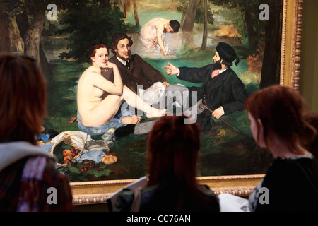 France, Paris, Visitors looking at Le Dejeuner sur l'herbe The Lunch on the Grass by Edouard Manet in Musee d'Orsay. Stock Photo
