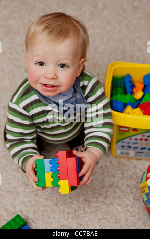 Young boy (1 year) playing with colourful lego bricks Stock Photo