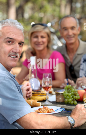 three seniors having lunch in the country Stock Photo