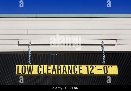 low clearance sign posted at entrance to parking structure Stock Photo
