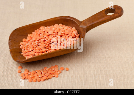 red lentils on a rustic wooden scoop against tablecloth Stock Photo