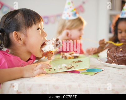 Girls enjoying cake at birthday party Stock Photo