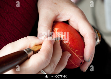 Hands etching a egg in Polish tradition of Pisanki Stock Photo