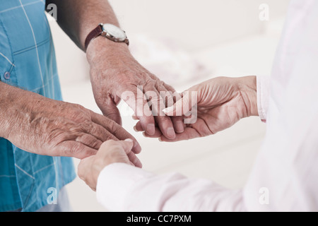 Close-up of Caregiver holding Patient's Hands Stock Photo