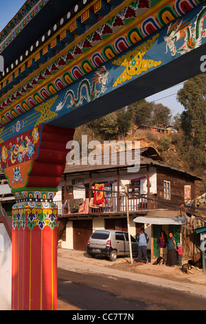 India, Arunachal Pradesh, Dirang bazaar, view of town through painted traditional Tibetan gateway of school Stock Photo