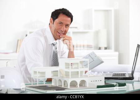 Friendly architect sat at his desk Stock Photo