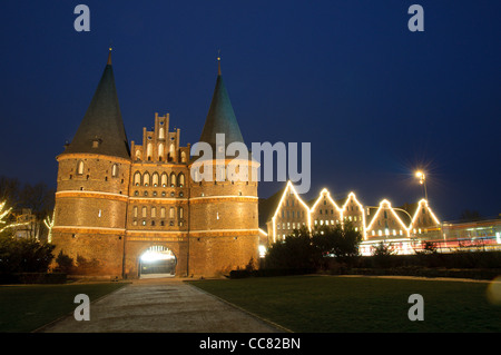 Illuminated Holstentor or Holsten Gate in the evening with Christmas decorations, Hanseatic City of Luebeck, Germany Stock Photo