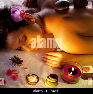 Young woman getting stones spa procedures. Stock Photo