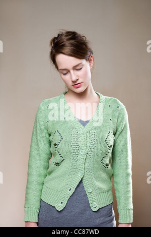 Portrait of exhausted looking young woman in green sweater. Stock Photo