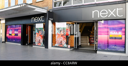 Retail business Next sign for clothing high street store and shop front window display in Brentwood High Street Essex England UK Stock Photo