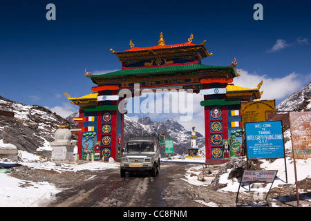 India, Arunachal Pradesh, Sela Pass, tata sumo 4WD car on high altitude road under colourful gateway to Tawang Stock Photo