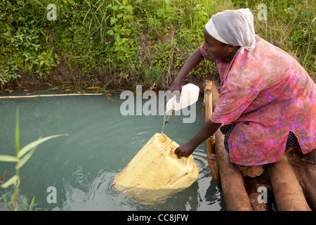 A woman fetches water in rural Masaka District, Uganda, East Africa. Stock Photo