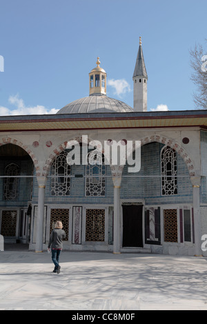 female Tourist exploring the Topkapi Palace Istanbul Dome and minaret tower Stock Photo