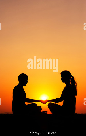 Indian man and indian girl holding the sun. Silhouette. India Stock Photo