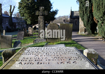 Eyam Churchyard in Derbyshire showing 8th century Celtic Cross and 1666 Tomb Stock Photo