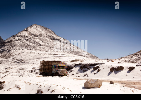 India, Arunachal Pradesh, truck driving through snow capped mountains surrounding Sela Pass Stock Photo