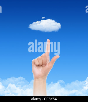 Woman hand point on cloud against blue sky with clouds. Concept image on cloud computing and eco theme. Stock Photo