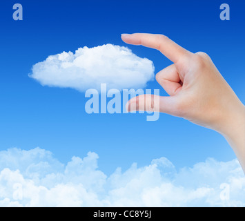 Woman hand measures the cloud against blue sky with clouds. Concept image on cloud computing and eco theme. Stock Photo