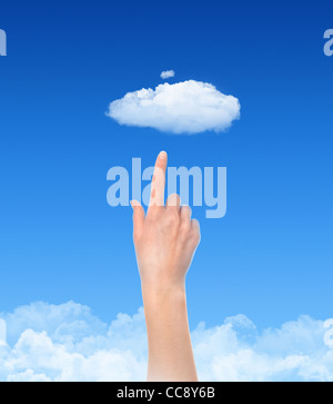 Woman hand touch the cloud against blue sky with clouds. Concept image on cloud computing and eco theme. Stock Photo