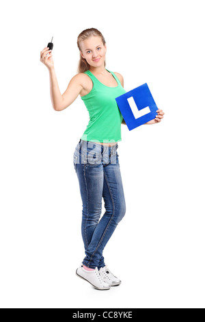 Full length portrait of a smiling teenager holding a L plate and car key Stock Photo