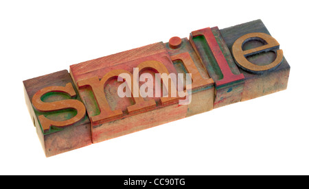 the smile word in vintage wooden letterpress type blocks, stained by color ink, isolated on white Stock Photo