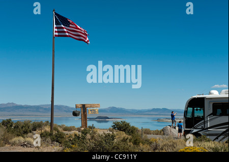 Tourists beside a Winnebago and the American flag, Mono Lake, Tioga Gas and Gift Mart. California. USA