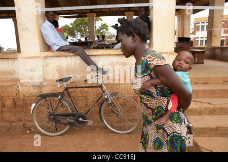 A mother carries her young child to a health centre in Kumi, Uganda, East Africa. Stock Photo