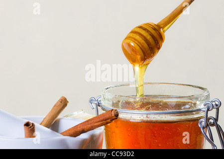 Honey dipper with jar on white background Stock Photo