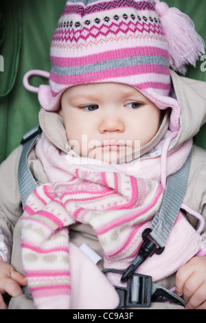 Close-up of Baby Girl Sitting in Car Seat wearing Winter Clothing Stock Photo